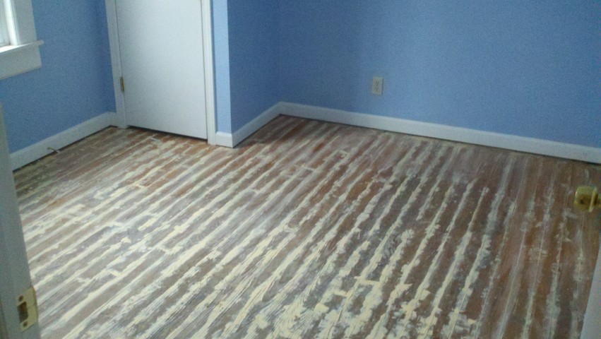 A hardwood floor showing signs of deep scratches and scuffs