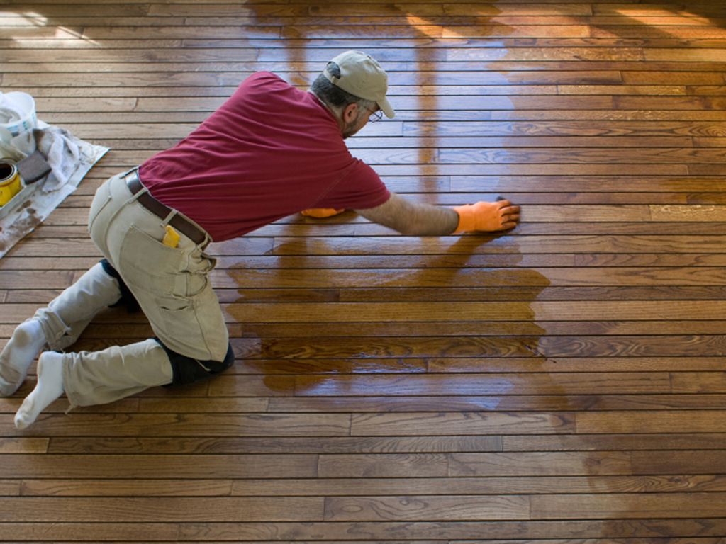 a madison floor refinisher hard at work updating a wood floor.