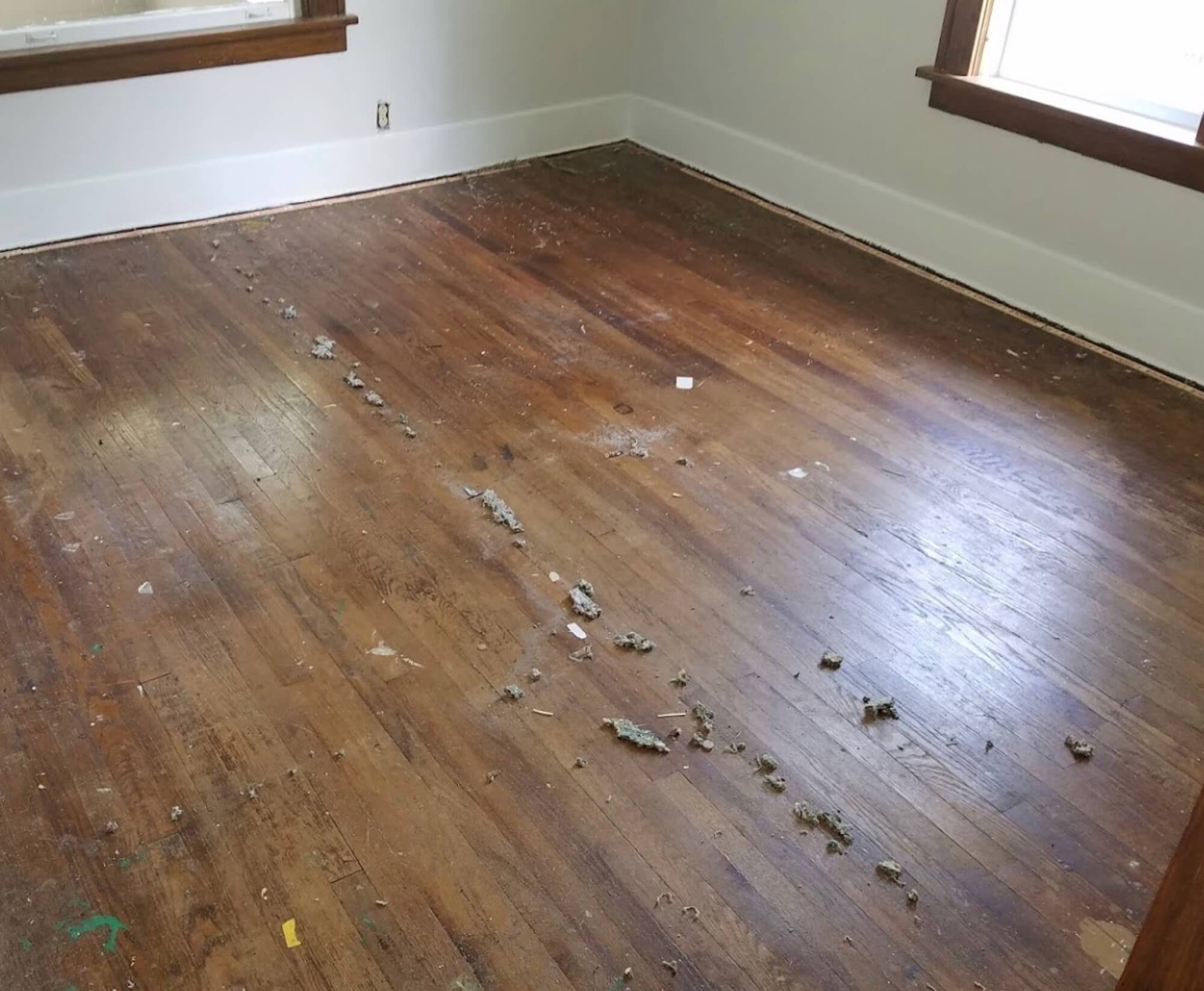 a damaged hardwood floor in a bedroom 
