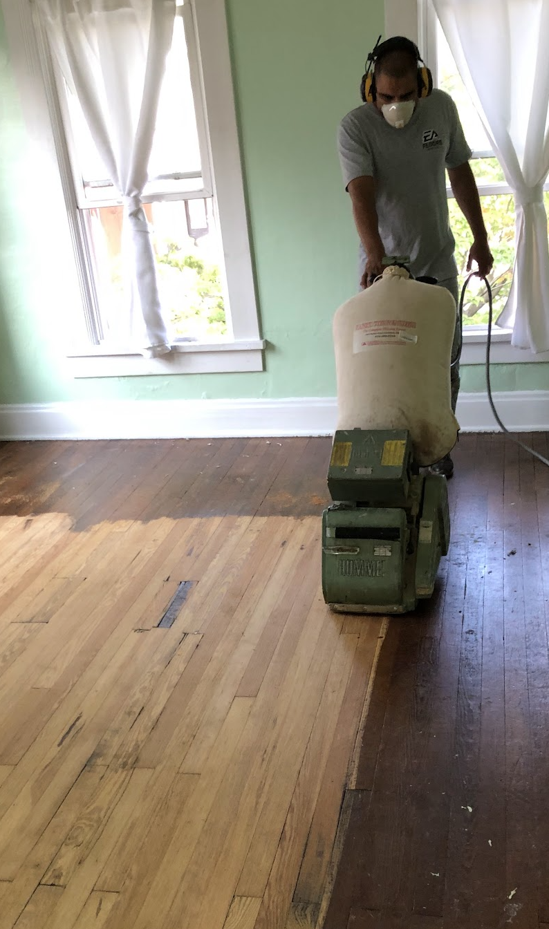 a technician refinishing a hardwood floor